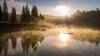 See in herbstlicher Morgensonne mit Nebel